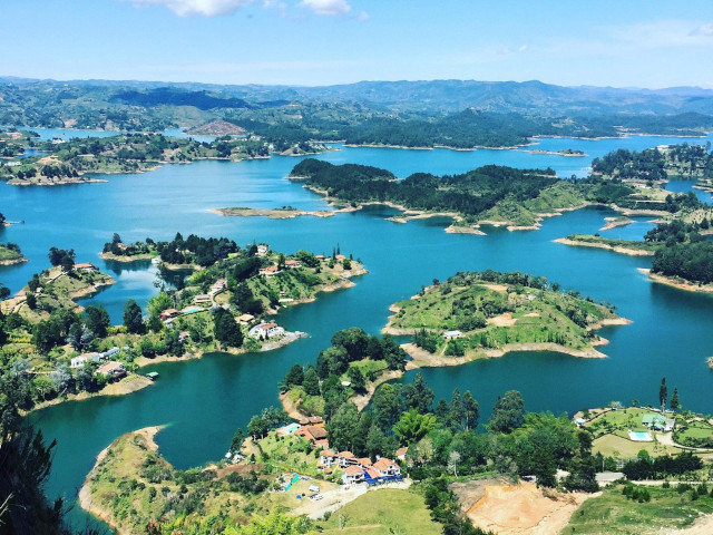 Guatapé Reservoir surrounded by mountains and lush vegetation.