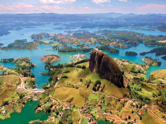 Panoramic view of Guatapé Reservoir surrounded by mountains and natural landscapes.